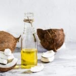 fresh-vegetable-coconut-oil-in-a-bottle-and-pieces-of-coconut-on-the-table-natural-cosmetic-photo